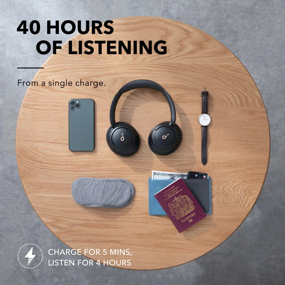 Anker headphones with 40 hours listening time, phone, watch, passport on wood table — Anker Kuwait