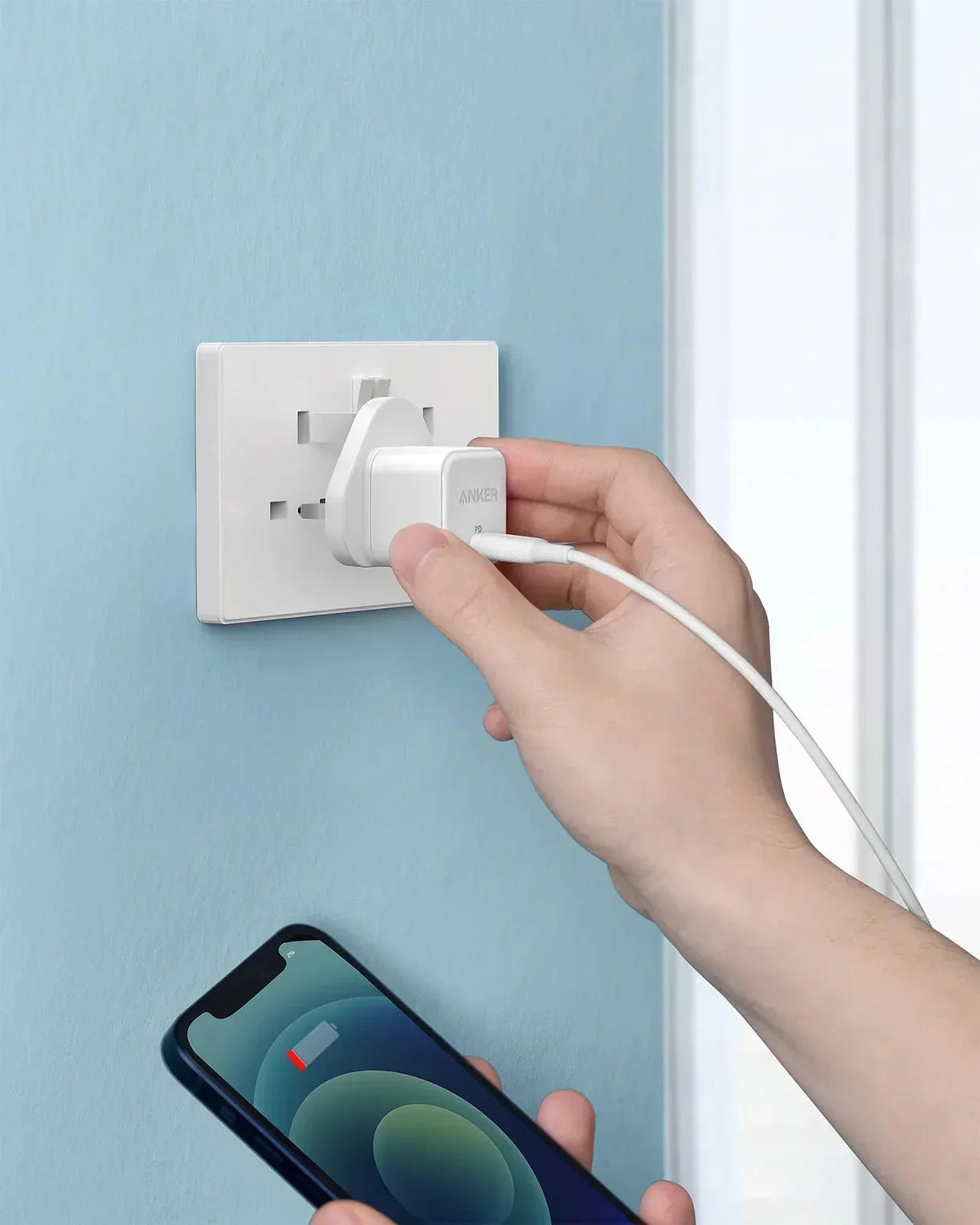 Anker fast charger plugged into wall outlet charging smartphone, Anker Kuwait