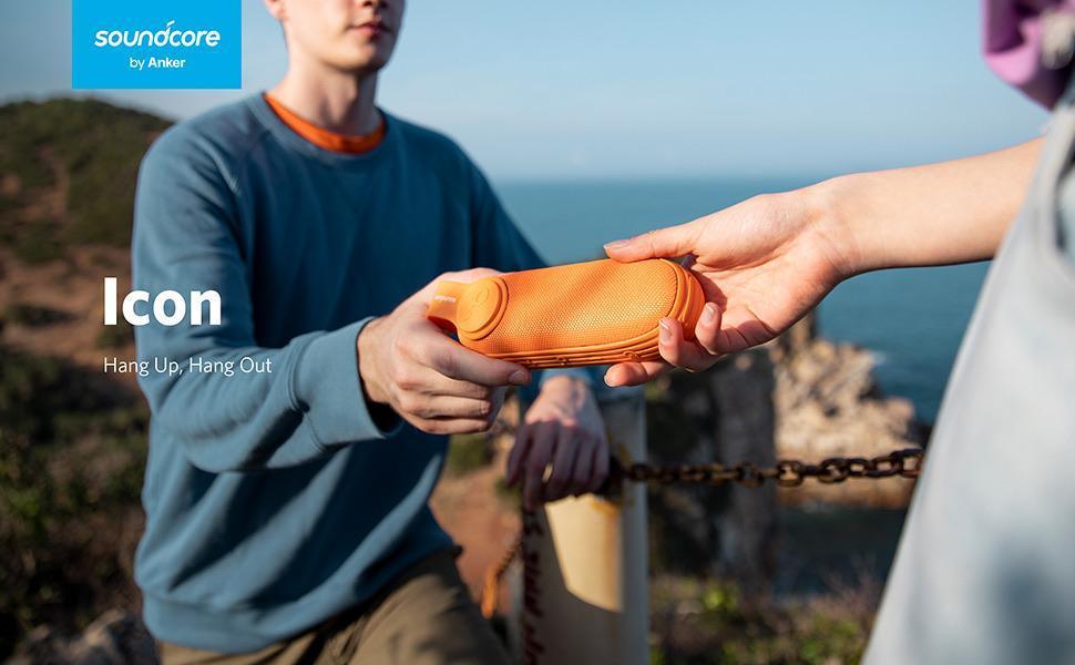 Orange Soundcore Icon portable speaker by Anker, shared outdoors near ocean, perfect for hangouts